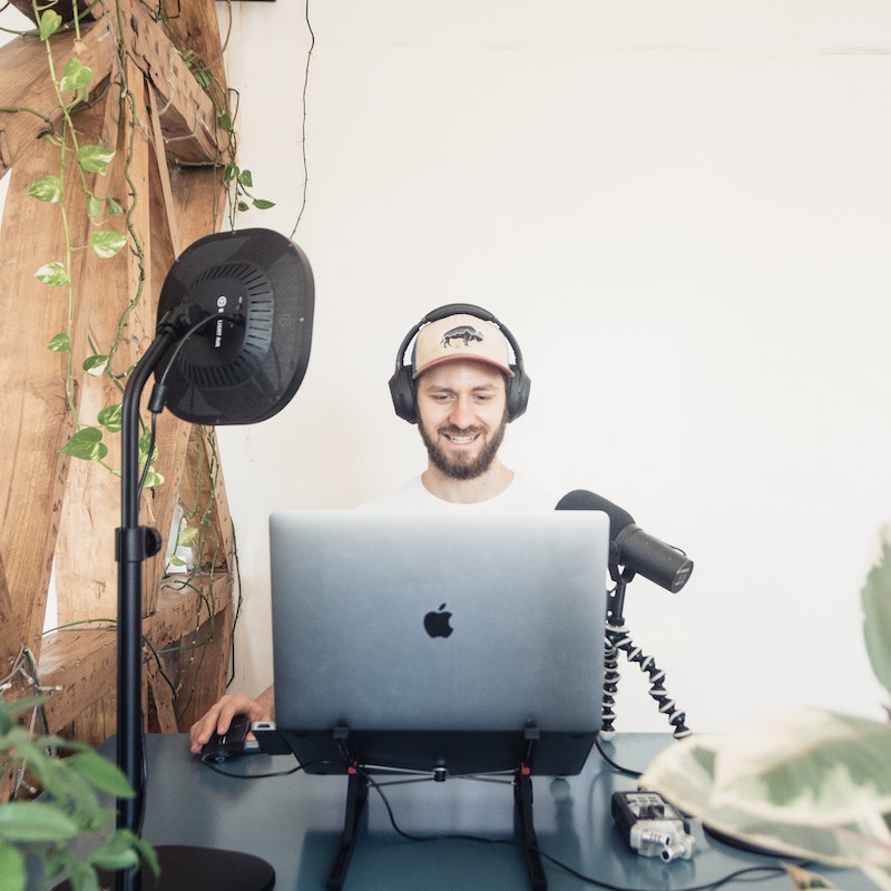Hombre freelance trabajando con su computadora y micrófono