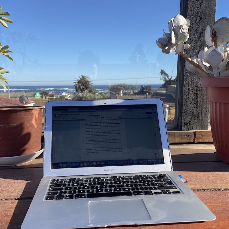 Computadora sobre mesa en una terraza en Pichilemu con vista al mar