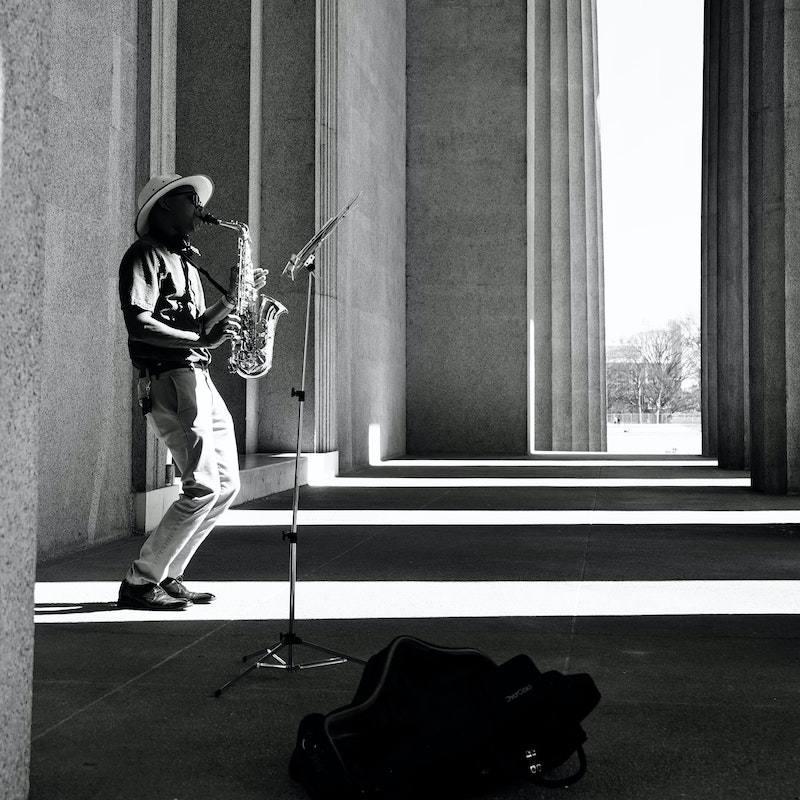 Hombre solitario tocando su saxofón en un espacio público