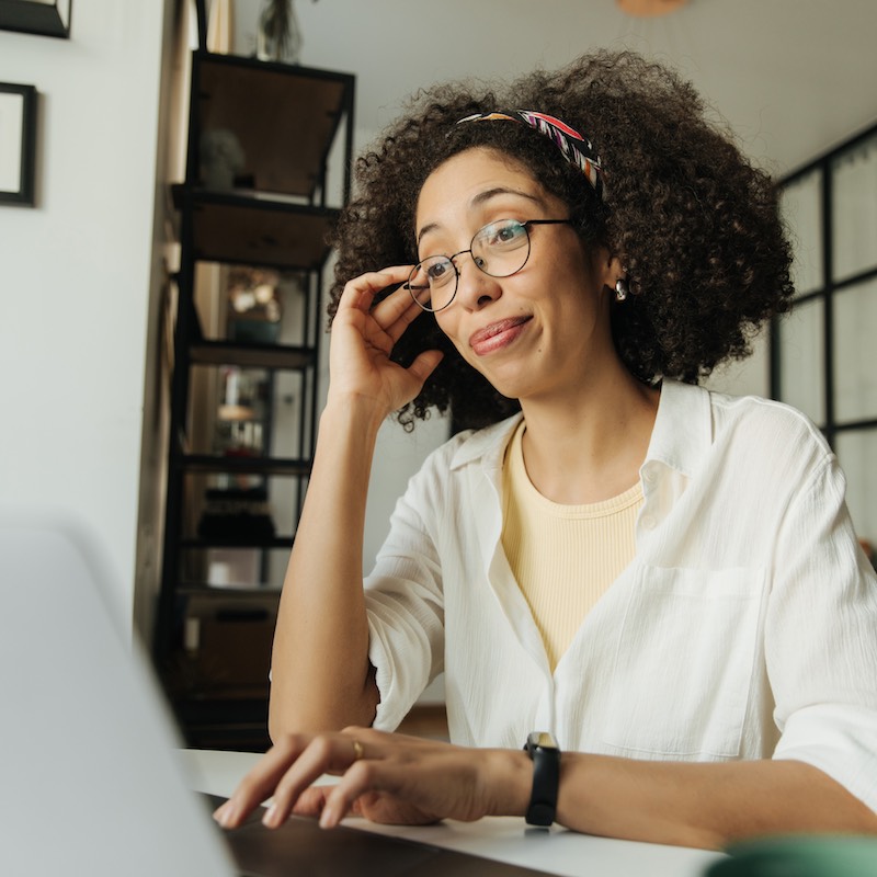 Mujer observando computadora con mueca