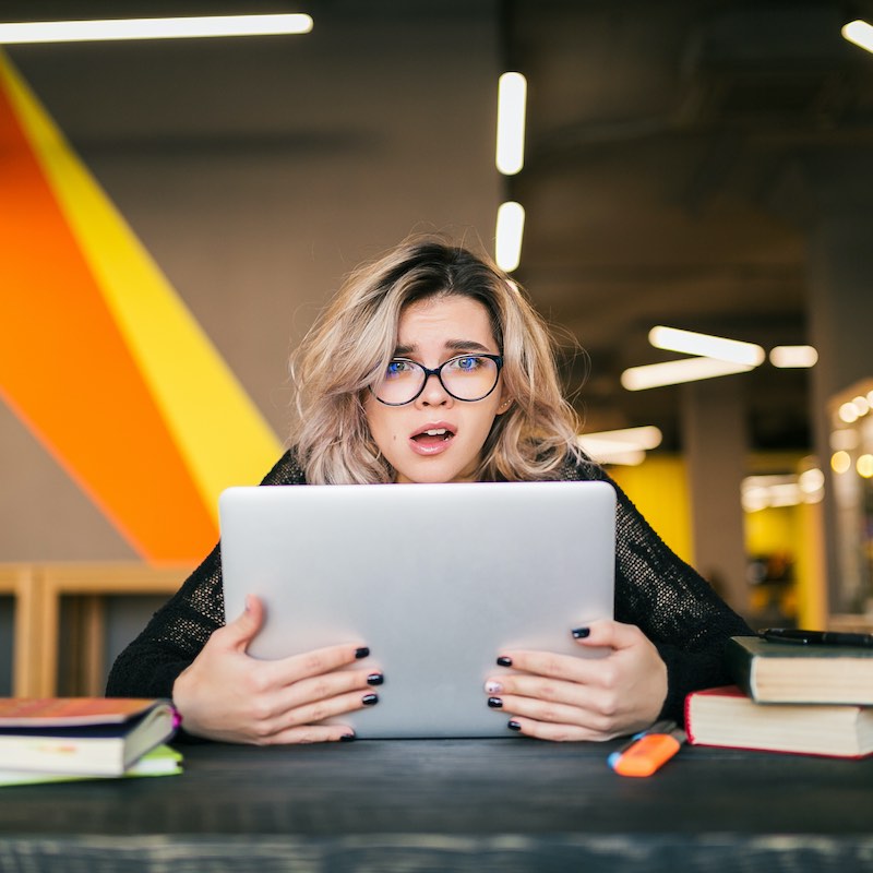 mujer frustrada con computadora en espacio de trabajo