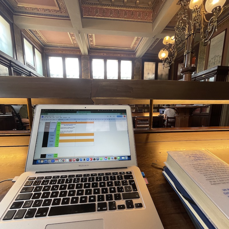 Computadora y libro sobre mesa en espacio de trabajo de la biblioteca Arùs en Barcelona