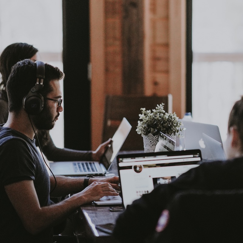 grupo de personas trabajando con sus computadoras en un coworking space