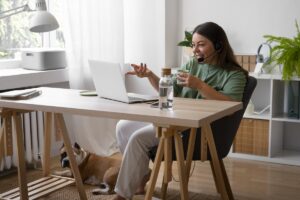 mujer sentada en mesa con su computadora sonriente